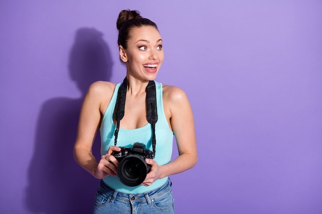 Retrato de close-up de garota jornalista segurando equipamento de câmera isolado em fundo roxo