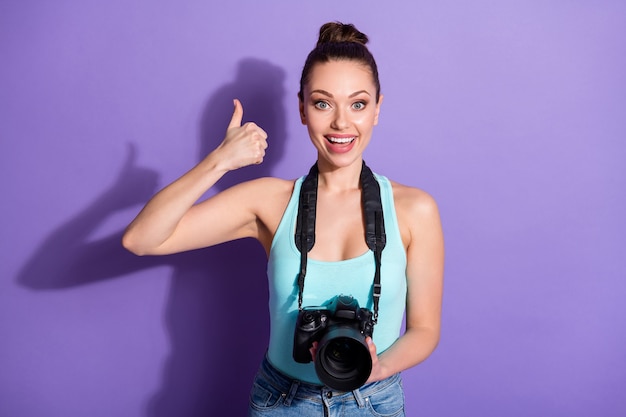 Retrato de close-up de garota jornalista segurando equipamento de câmera isolado em fundo roxo