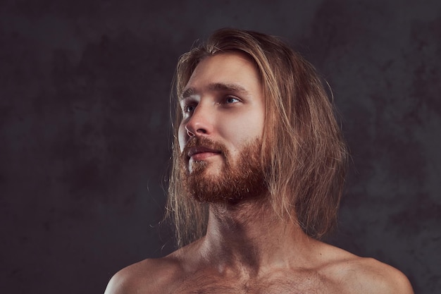 Retrato de close-up de homem bonito ruiva sem camisa, isolado em fundo escuro.