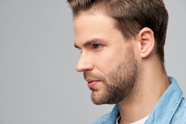 Retrato de close-up de jovem homem bonito caucasiano em camisa jeans.