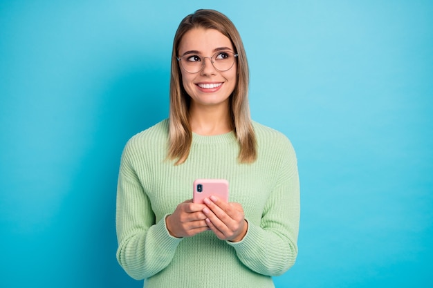 Retrato de close-up de sua bela garota atraente adorável alegre alegre usando a célula criando um novo aplicativo multimídia pós-mídia 5g isolado sobre fundo de cor azul vibrante de brilho vívido brilhante