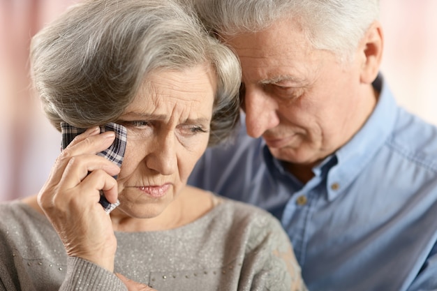 Retrato de close-up de um casal de idosos tristes na cor de fundo