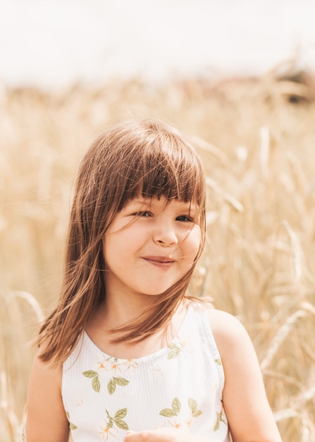 Retrato de close-up de uma menina loira sorridente na natureza no verão