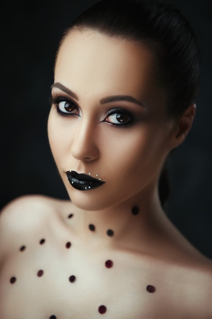 Retrato de close-up de uma modelo linda com maquiagem escura