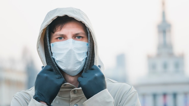 Retrato de close-up jovem europeu com máscara protetora médica e descartável caminhando ao ar livre