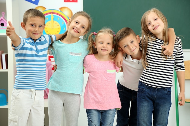 Retrato de colegas felizes olhando para a frente na sala de aula