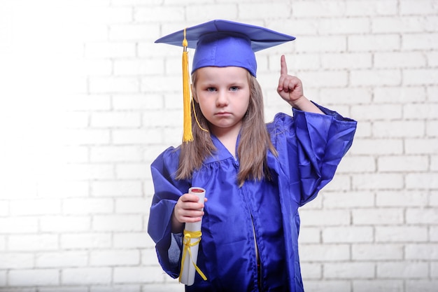 Foto retrato de colegial bonito com chapéu de formatura na sala de aula