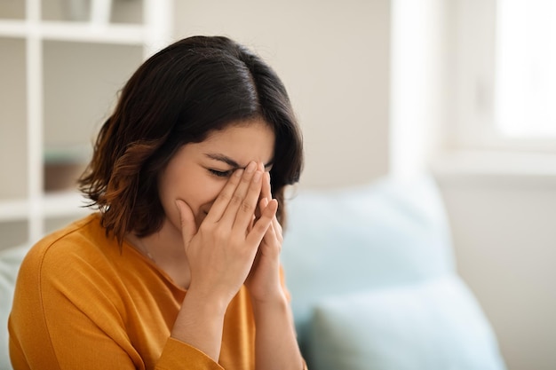 Retrato de conceito de depressão de jovem árabe chorando enquanto está sentado em casa