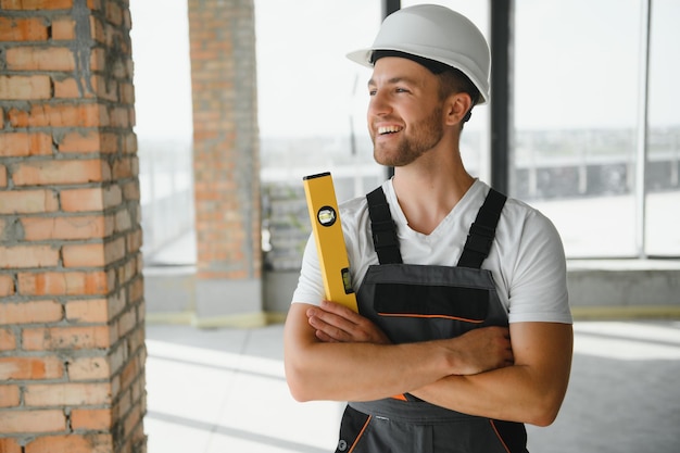 Retrato de construtor masculino bonito de macacão e capacete