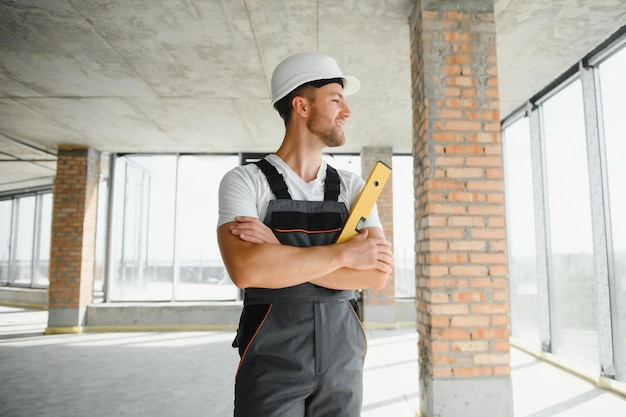 Retrato de construtor masculino bonito de macacão e capacete
