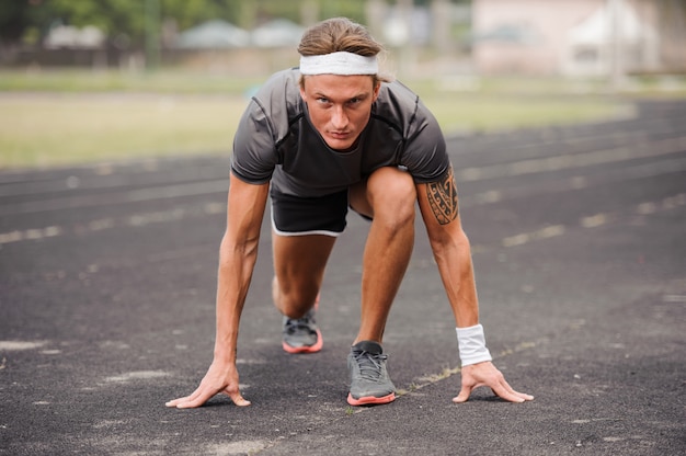 Retrato de corpo inteiro de homem atleta pronto para correr