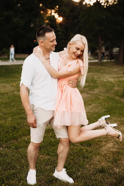 Retrato de corpo inteiro de um adorável marido e mulher se divertindo rindo ao ar livre.