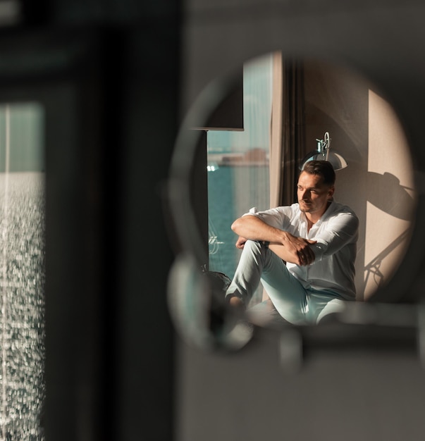 Retrato de corpo inteiro de um jovem bonito de terno elegante posando em apartamentos luxuosos