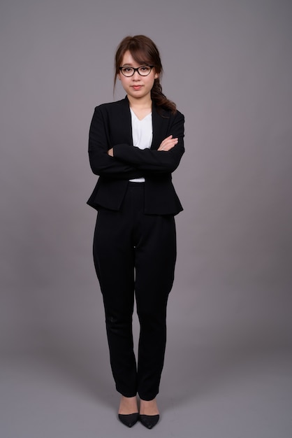 Retrato de corpo inteiro de uma jovem empresária asiática em pé
