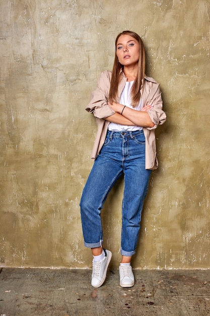 retrato de corpo inteiro de uma jovem mulher branca posando para a câmera