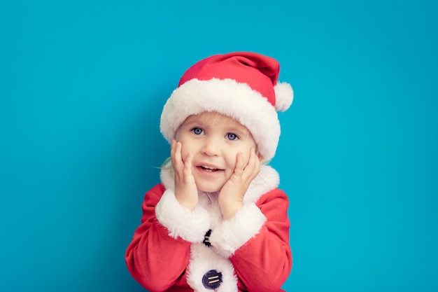 Retrato de criança com fantasia de Papai Noel. Garoto se divertindo na época do Natal. Conceito Merry Xmas