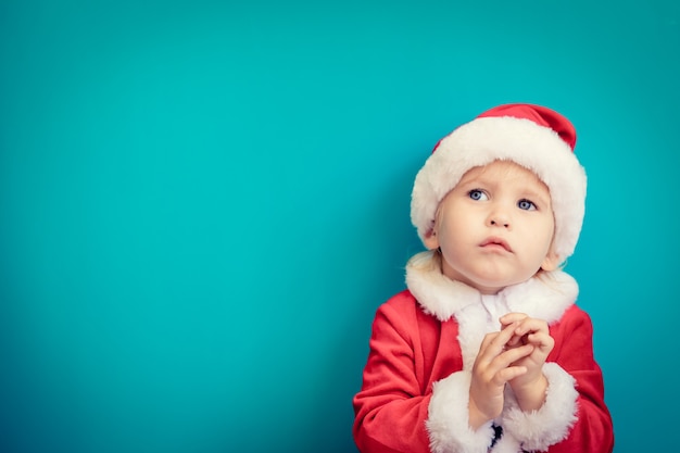 Retrato de criança com fantasia de Papai Noel. Garoto se divertindo na época do Natal. Conceito Merry Xmas