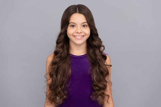 Retrato de criança de frizz em criança de vestido roxo com penteado de beleza adolescente de cabelo encaracolado