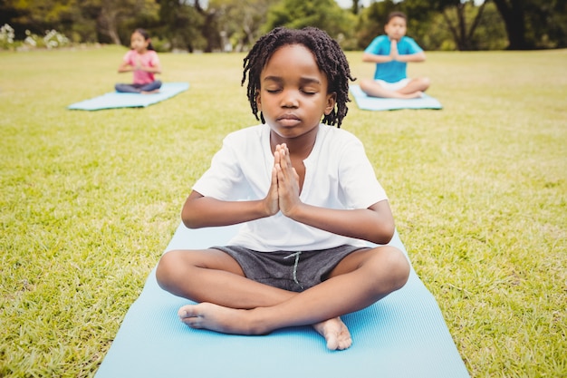 Retrato de criança fazendo yoga com amigos