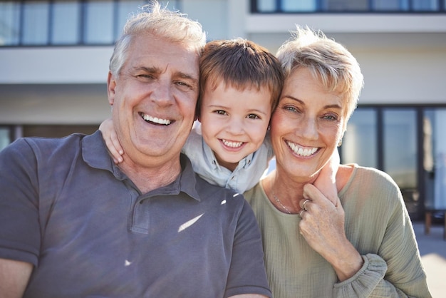 Retrato de criança feliz e avós juntos ao ar livre com sorriso, amor e vínculo com a família homem e mulher sênior se divertindo felicidade e alegria com menino bonito ou criança em um fim de semana no quintal