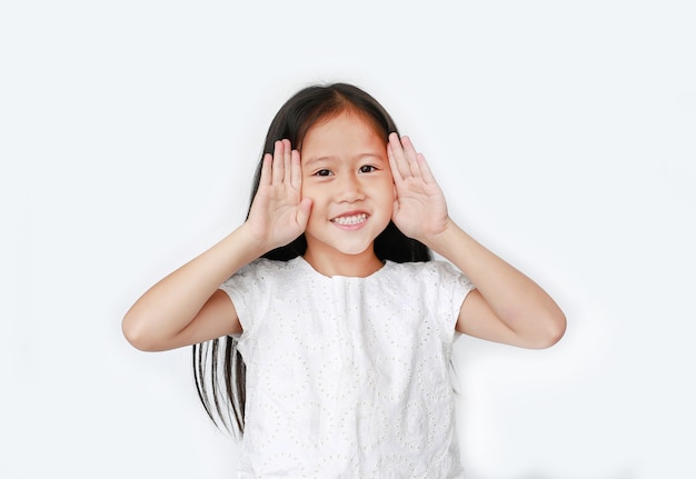 Retrato de criança feliz menina gestos jogando peekaboo. Postura de criança abrir as mãos dos olhos com um sorriso.