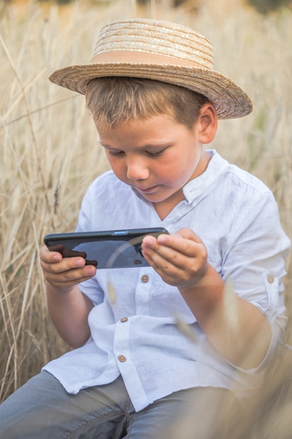 Retrato de criança Garotinho em um campo de trigo