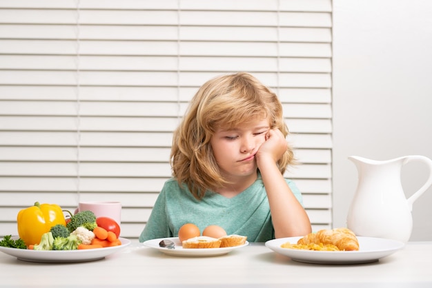 Retrato de criança sem conceito de apetite de perda de apetite criança come vegetais saudáveis de alimentos orgânicos