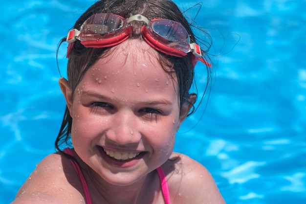 Retrato de criança sorridente na piscina em óculos de férias de verão viagens de hotel ou aulas