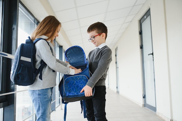 Retrato de crianças de escola sorridentes no corredor da escola com livros