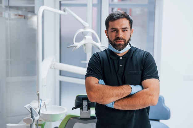 Retrato de dentista em luvas que estão dentro de casa na clínica.