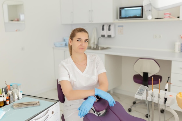 Retrato de dentista feminina Ela de pé em seu consultório de dentista