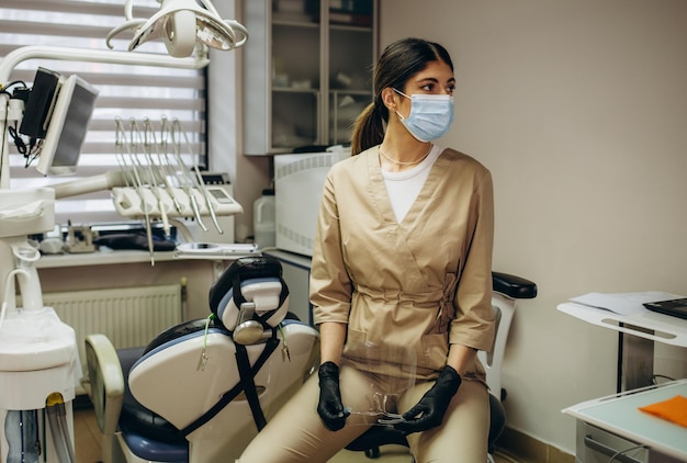 Retrato de dentista feminina Ela de pé em seu consultório de dentista