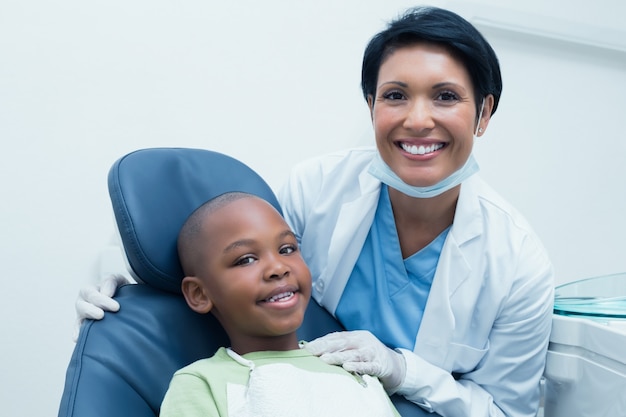 Retrato de dentista feminino examinando meninos dentes