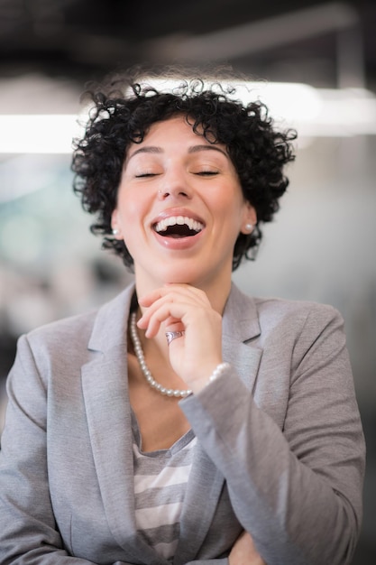 Retrato de desenvolvedora de software feminina bem-sucedida com um penteado encaracolado no escritório de inicialização moderno