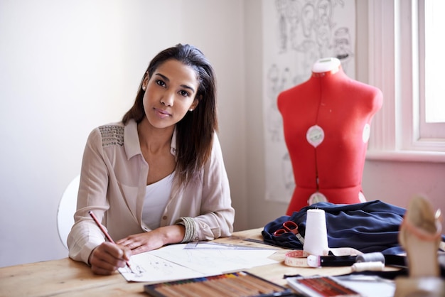 Foto retrato de designer de moda e mulher de negócios desenhando em papel com lápis em um escritório de startup pessoa criativa e rosto de alfaiate esboço na mesa profissional ou empregado trabalhando em um projeto no brasil