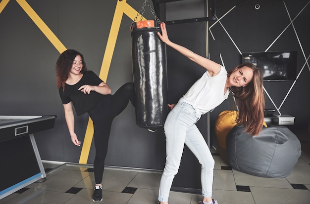 Retrato de divertidos boxeadores vestidos de jeans e camisetas no centro de jogos.