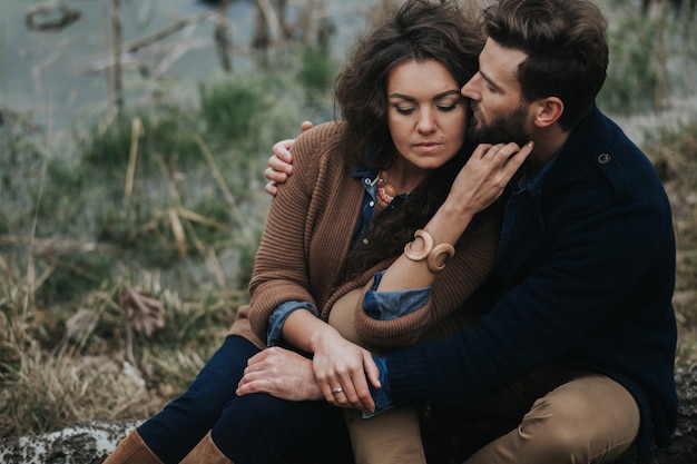 Retrato de dois amantes caucasianos. Jovem casal está abraçando no dia de outono ao ar livre. Um homem barbudo e uma mulher encaracolada apaixonados. Dia dos namorados.