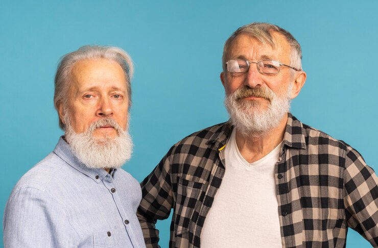 Foto retrato de dois amigos idosos em pé sobre amizade de fundo azul idosos e pessoas idosas
