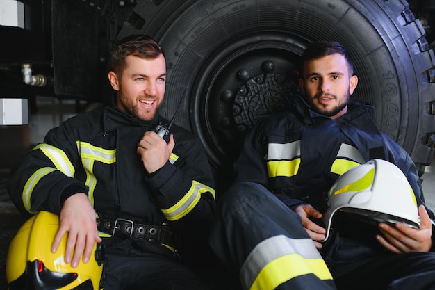 Retrato de dois bombeiros heróicos em traje de proteção e capacete