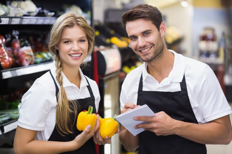 Foto retrato de dois colegas com vegetavles e escrevendo no bloco de notas
