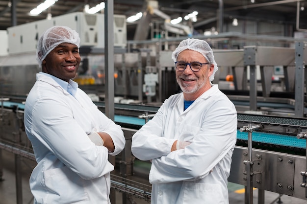 Retrato de dois engenheiros de fábrica em pé com os braços cruzados