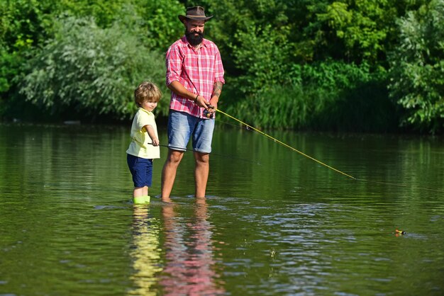 Retrato de dois homens de geração pescando o conceito de uma idade de aposentadoria, pequeno ajudante pescando pai feliz