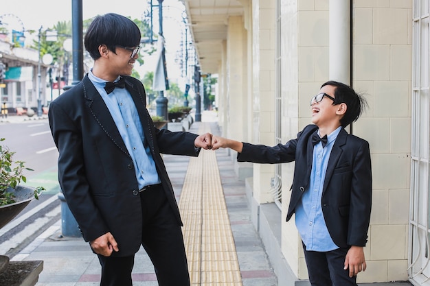 Retrato de dois irmãos com traje vintage batendo os punhos