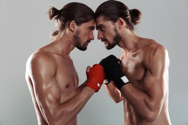 Retrato de dois irmãos gêmeos musculosos sem camisa