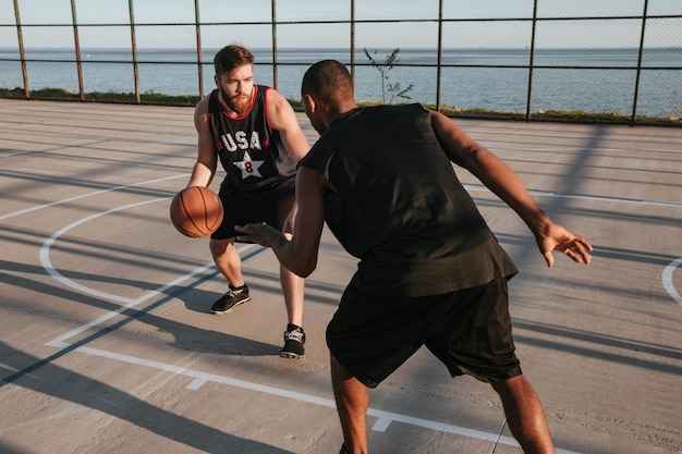 Retrato de dois jovens atletas jogando basquete no parquinho