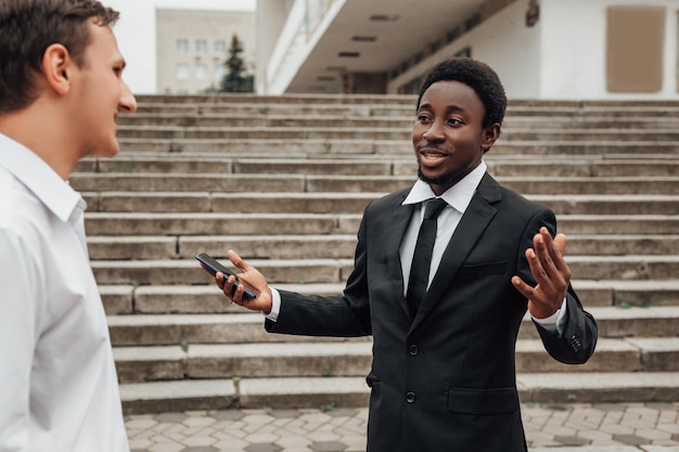 Retrato de dois jovens empresários confiantes descendo as escadas e conversando