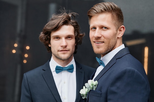 Retrato de dois jovens sorridentes vestindo ternos durante a cerimônia de casamento conceito de casamento do mesmo sexo