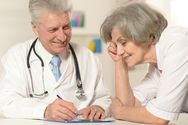 Retrato de dois médicos seniores à mesa