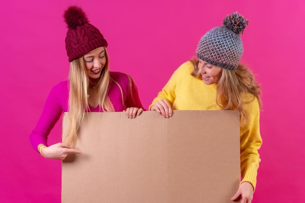 Retrato de dois muito atraentes encantadores encantadores bastante confiantes alegres segurando em sinal de venda de mãos isolado sobre fundo rosa