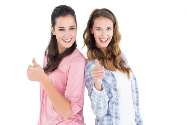 Foto retrato de duas amigas gesticulando polegares para cima